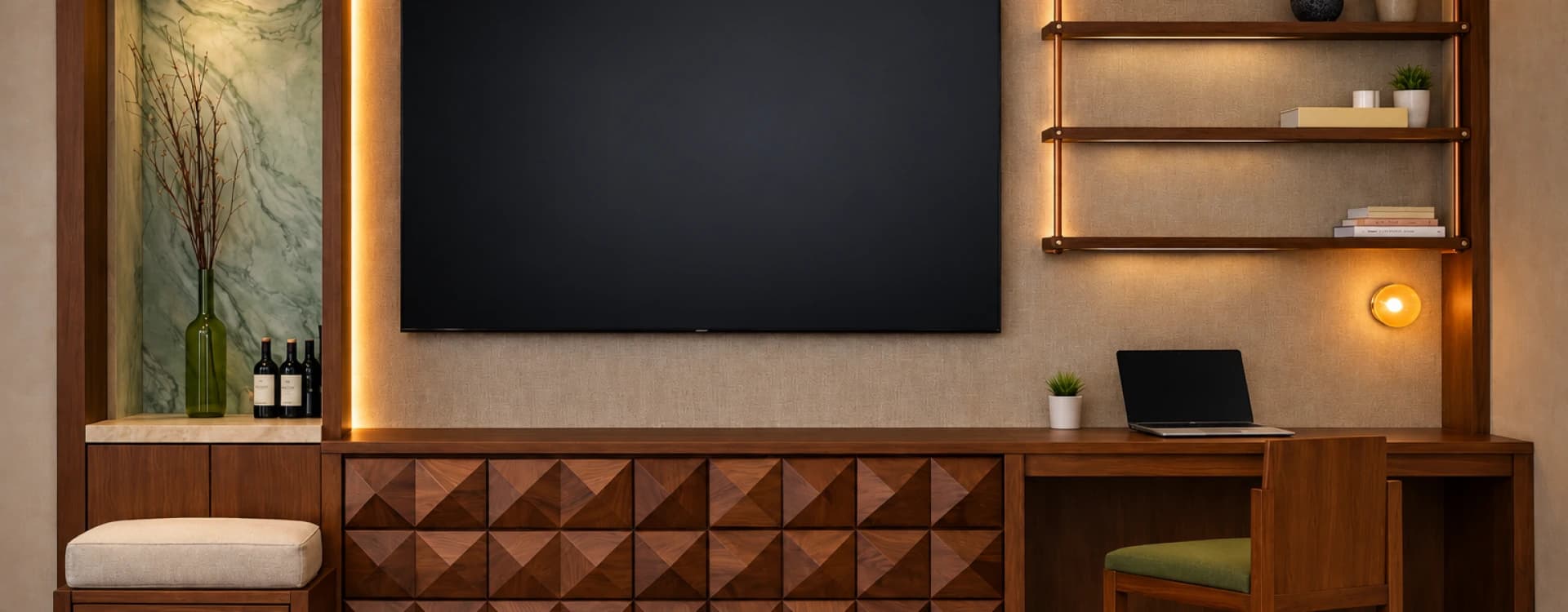 A television above a geometric wood cabinet, beside a desk and lit floating shelves