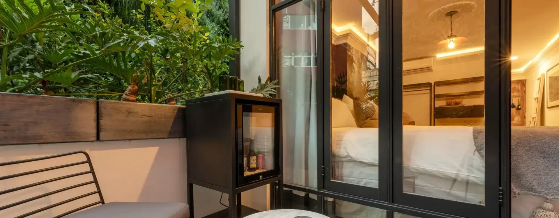 Terrace with a vertical garden, a minibar and a marble table facing the room's window wall